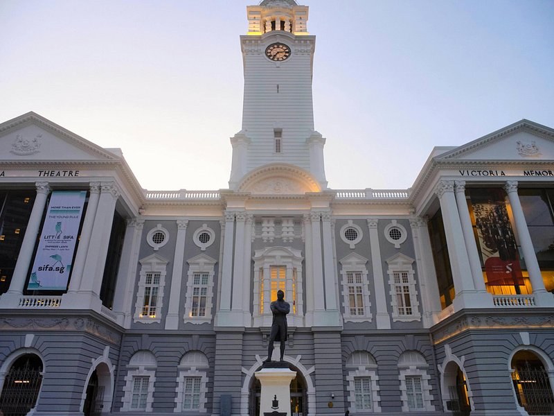 The clock tower of Victoria Theatre and Concert Hall above the Raffles statue in the civic district